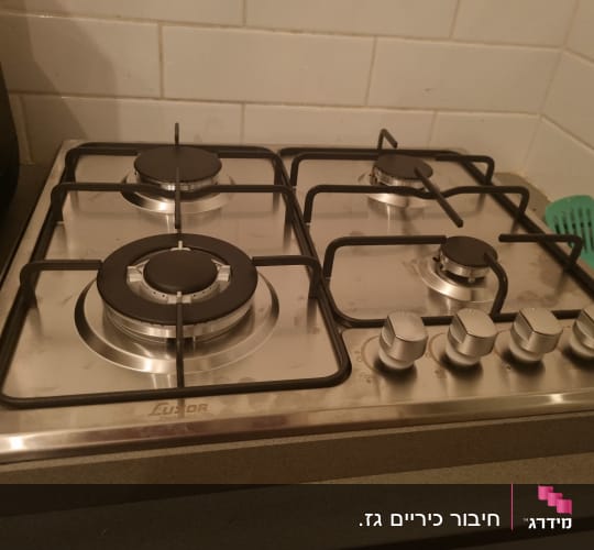 כיריים גז עם ארבעה מבערים וכפתורי שליטה